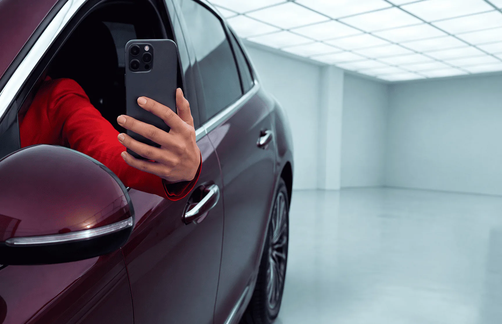 Driver using a smartphone beside a car
